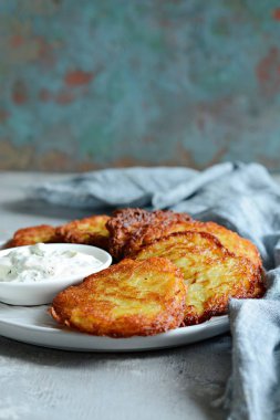 Yeşil salata ve yoğurt soslu çıtır patates krep. Patates böreği yığını