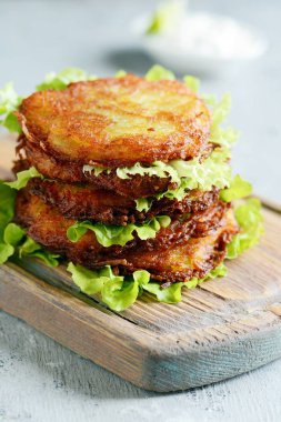 Yeşil salata ve yoğurt soslu çıtır patates krep. Patates böreği yığını