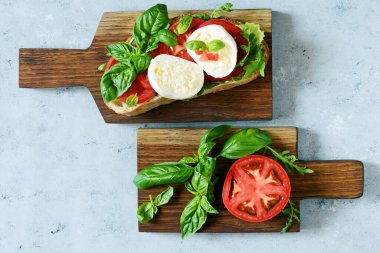 İtalyan aperatifi the Caprese Salatası ile mavi arka planda ahşap bir salata, İtalyan panini yakın görüntüsü - taze malzemelerle.