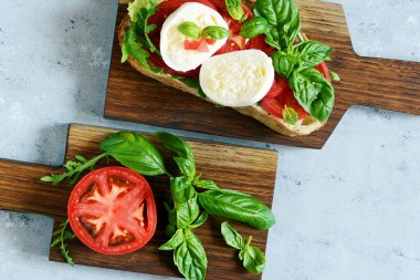 İtalyan aperatifi the Caprese Salatası ile mavi arka planda ahşap bir salata, İtalyan panini yakın görüntüsü - taze malzemelerle.