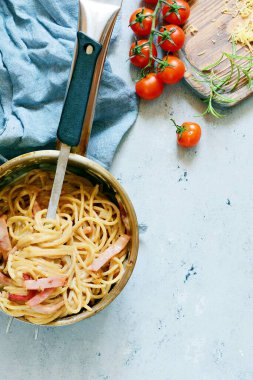 Pastırmalı makarna ve gri tabakta parmesan, mavi arka planda restoran servisi. Geleneksel İtalyan mutfağı. Aile yemeği. Yukarıdan bak.