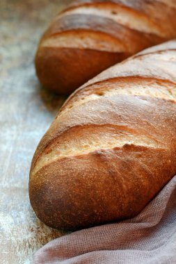 Kahverengi arka planda taze ekmek. Geleneksel buğday taze rustik ekmek, bir somun ekmek.