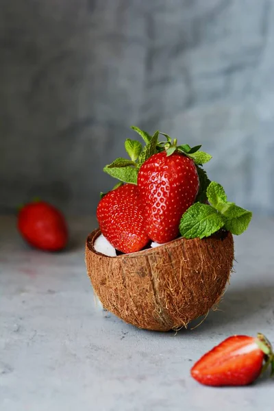 배경에 코코넛 반쪽에 딸기가 익었다 맛있는 디저트 건강에 — 스톡 사진