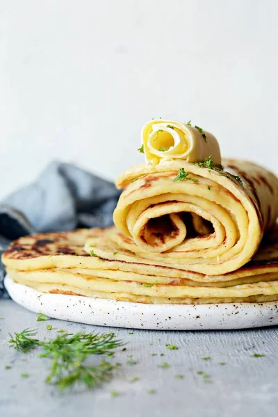Peynir ve yeşilliklerle donatılmış hafif arka planda Norveç patatesli krep Lefse. Geleneksel İskandinav mutfağı.