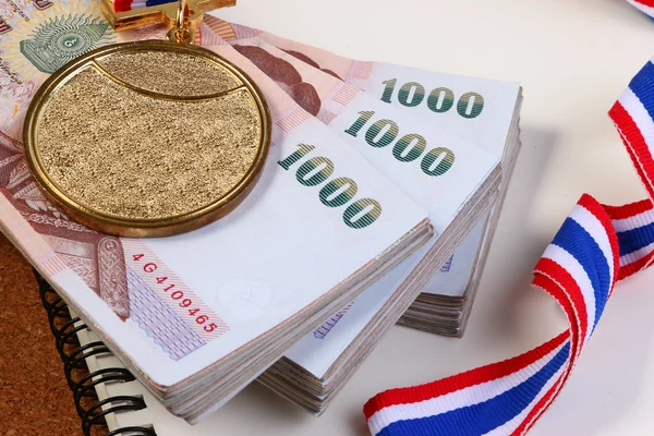 Zlatá medaile a thajské peníze. Sportovní úspěchy v platbách. — Stock fotografie