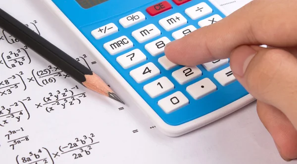 Calculadora de prensa manual sobre ecuaciones matemáticas o matemáticas . — Foto de Stock