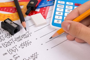 Kalem tutan el ile matematik ikinci dereceden Denklem. Matematikte kullanılan okul malzemeleri.