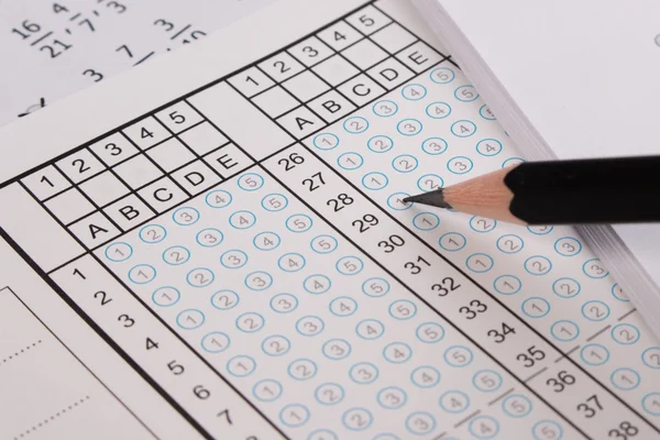 La hoja de respuestas se centra en el lápiz. Hoja de respuesta de burbuja con respuesta en blanco. Examen escolar hoja de respuesta y pluma . — Foto de Stock