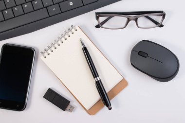 Ofis malzemeleri, bilgisayar aygıt ve defter kalem üzerinde beyaz arka plan üzerinde izole iş yeri ile.