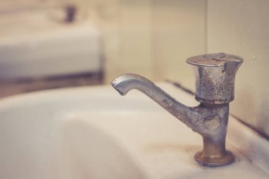 Eski faucent tuvalet içinde. İsraf su, su dokunun içinde kirli umumi tuvalet.