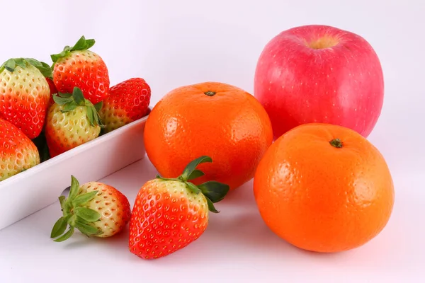 Strawberry, apple and mandarin orange from market in a white bowl isolated on white background.