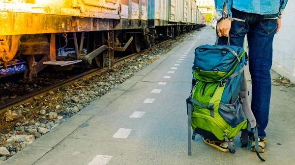 Mochilero esperando un viaje largo en la estación de tren con mochila. Concepto de viaje con filtro vintage . — Foto de Stock