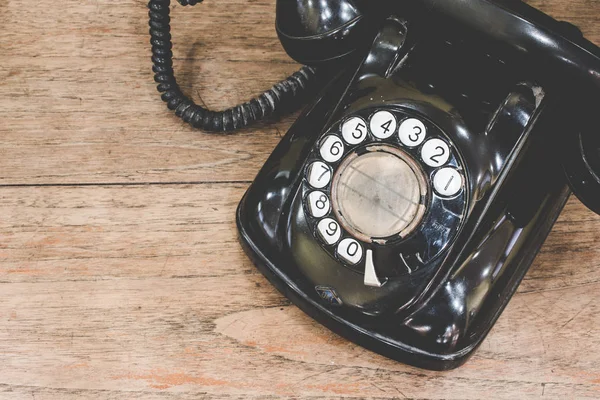 Siyah, antika, analog telefon çevirme veya ahşap masada kaydırmalı telefon. Konsept ile bağlantı kur.