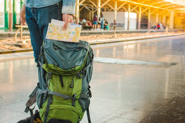 Mochilero esperando un viaje largo en la estación de tren con mochila. Concepto de viaje con filtro blanco y negro . — Foto de Stock