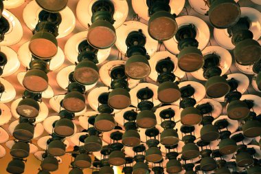 Eski tip fırtına fenerlerinden oluşan bir grup tavan tahtasına asılmış kasırga lambası. Klasik lamba konsepti.