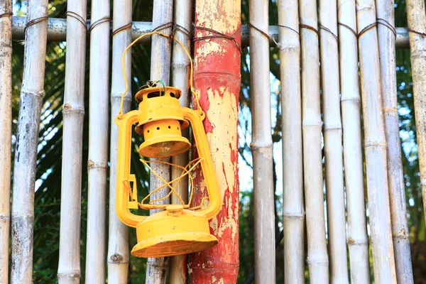 Colorful asia vintage kerosene oil lantern hang on bamboo wall for decorate in garden.