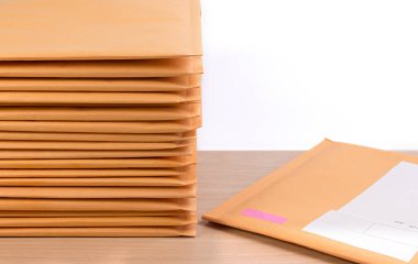 Bubble Wrap yığın posta zarfların üstüne beyaz arka plan rengi ahşap masa üzerinde sıfır. Zarf ambalaj darbeye dayanıklı yığın kavramı.