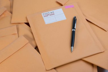 Bubble Wrap yığın posta zarflar ve kalemi beyaz arka plan rengi üzerinde ahşap masa üzerinde sıfır. Zarf ambalaj darbeye dayanıklı yığın kavramı.