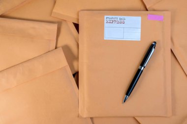 Bubble Wrap yığın posta zarflar ve kalemi beyaz arka plan rengi üzerinde ahşap masa üzerinde sıfır. Zarf ambalaj darbeye dayanıklı yığın kavramı.