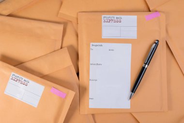Bubble Wrap yığın posta zarflar ve kalemi beyaz arka plan rengi üzerinde ahşap masa üzerinde sıfır. Zarf ambalaj darbeye dayanıklı yığın kavramı.