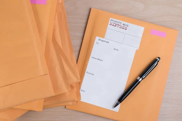 Bubble Wrap yığın posta zarflar ve kalemi beyaz arka plan rengi üzerinde ahşap masa üzerinde sıfır. Zarf ambalaj darbeye dayanıklı yığın kavramı. — Stok fotoğraf