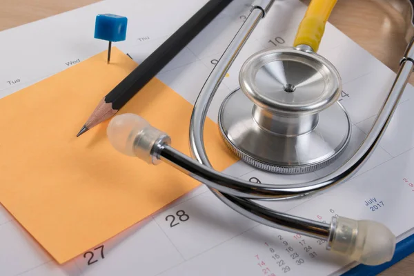 Stetoskop kitap ve kalem takvim, Doktor randevu kapatın. Uyarı mektubu planı sağlık check-up için rezervasyon.