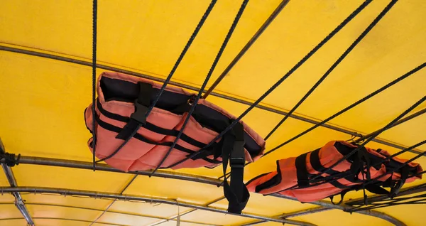 Orange life jacket or life vest hanging on the roof boat. Boat capsized concept.