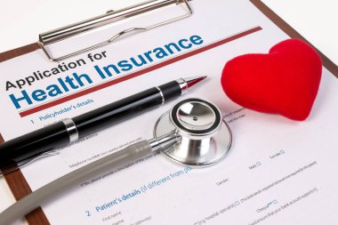 Sağlık sigortası başvuru formu, evraklar, kalem, kalp ve stetoskop anketi. Kalp konsepti olan sağlık sigortası hizmeti.