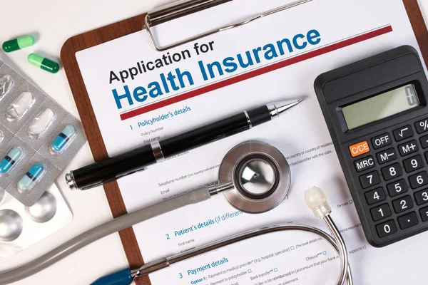 Application form for health insurance, paperwork, questionnaire, pen, tablet, calculator and stethoscope. Calculate for health insurance with service mind concept.