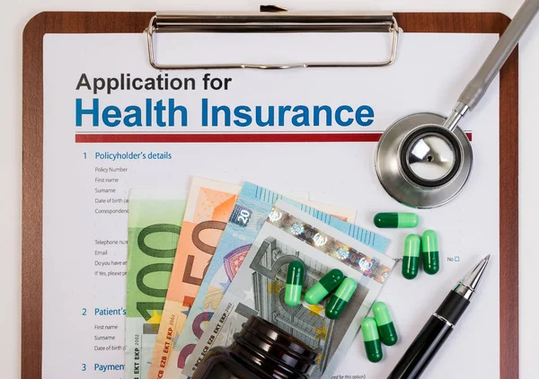 Application form for health insurance, paperwork, questionnaire, pen, tablet, calculator, money and stethoscope. Calculate for health insurance concept.