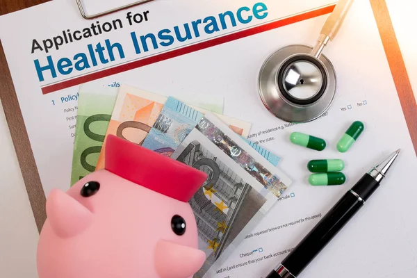 Application form for health insurance with piggy bank, stethoscope, money.