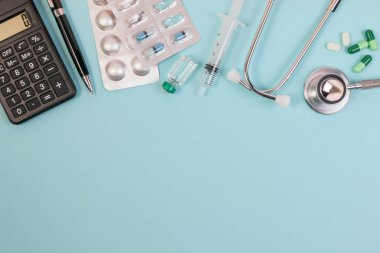 Çalışma alanı ile bir stetoskop, hesap makinesi, aşı ve tıbbi doktor ekipman.
