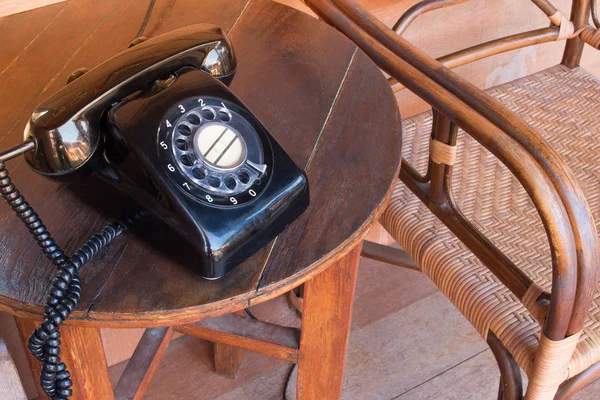 Régi fekete telefon por, kör dial pad és a karcolásoktól, fából készült retro asztal. — Stock Fotó