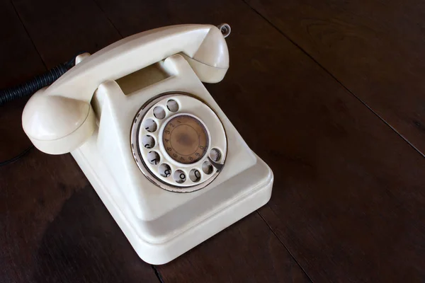 Régi fehér telefon por, kör dial pad és a karcolásoktól, fából készült retro asztal. — Stock Fotó
