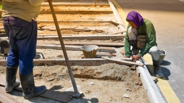 Kimliği belirsiz işçisi kürek kum yol inşaat sahasında bir kürek ile bir delik kazılar.