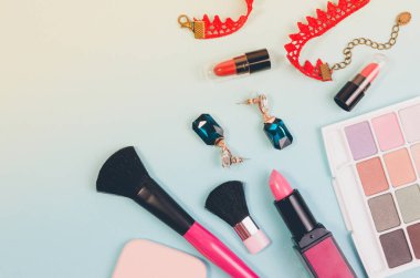 Çeşitli makyaj kozmetik, fırçalar, kolye ve diğer temel sarı ve mavi arka plan üzerinde görünümü top. Güzellik kozmetik için arka plan kavramı.