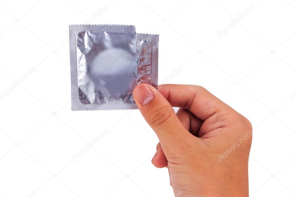 Asian boy hand holding foil condom package isolated on white background.