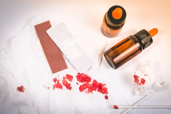 Fresh bleeding wounds or blood on tissue paper with first aid supplies, first aid equipment or emergency medical products.