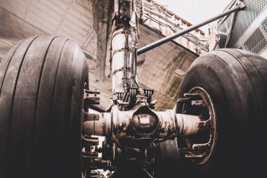 Uçak tekerlek ve şaft yakın çekim. Büyük uçak lastik şaft ve uçak altında uçağın iniş takımları.