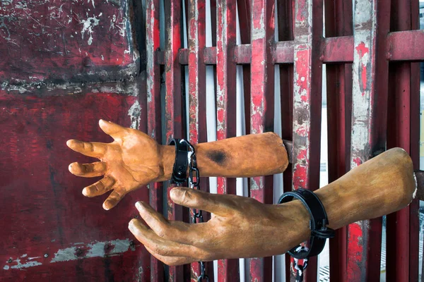 Human hand of ghost prisoner on steel lattice close up for Halloween background. Criminal hand show on steel lattice for help.