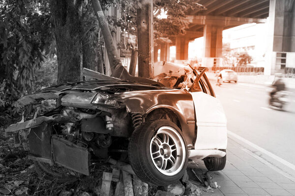 Asia car accident critical, car crashes in to tree and electric pole on sidewalk. Car crash in Asia with light effect for background.