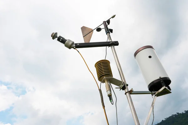 Meteorological weather station antenna with meteorology sensors and pale overcast cloudy sky in background. Weather station for background.