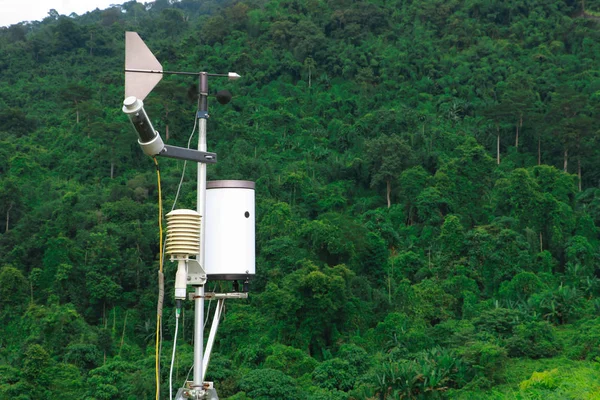 Antenna of meteorological weather station with meteorology sensors and forest in background. Weather station for background.
