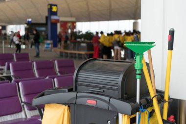 Uluslararası havalimanında arka plan için terminal kapısının önünde grup yolcusu olan temizlik seti ve süpürge kovası. Havaalanı temizlik ekipmanları.