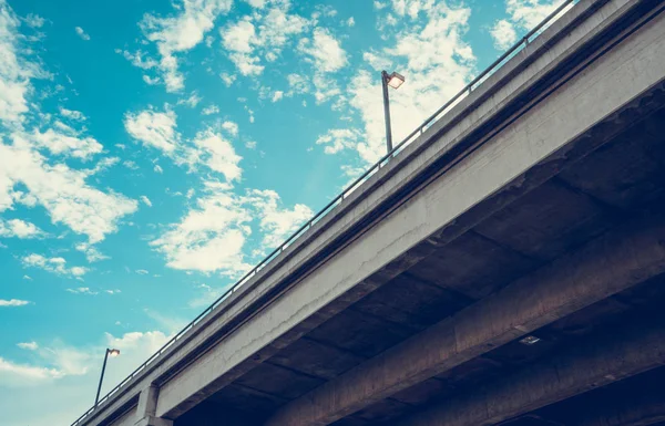 Worm\'s eye view of express way or hightway bridge with beautiful clear blue sky. Bridge and blue sky for business success concept with copyspace for text.