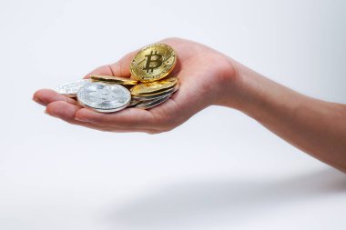 Asyalı genç el iki elinde bir sürü altın Bitcoin ve gümüş Bitcoin tutuyor. Bitcoin 'i beyaz arkaplanda izole edilmiş bir şekilde açık elle kapat.