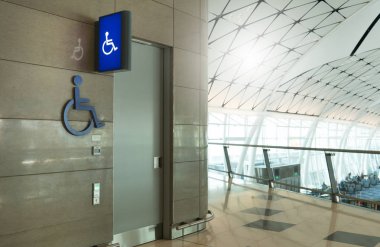 Umumi tuvaletin ya da erkekler için umumi tuvaletin önünde Weman, uluslararası havaalanında engelli işaretli ışıklı insanları engelledi. Engelli tuvalet kavramı.