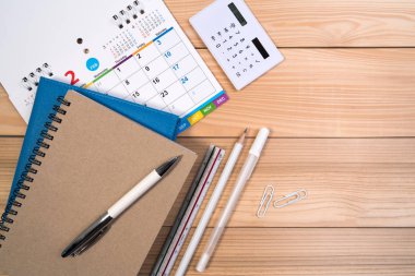 İş finansmanı veya randevu konsepti için kalem, hesap makinesi, defter ve günlük takvimi. Üst görünüm.