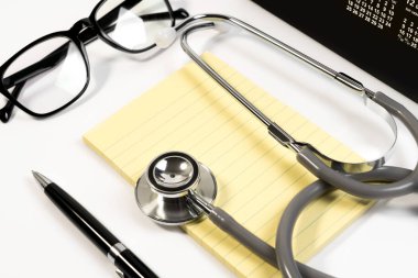 Stetoskop, kağıt not, defter, gözlük, kalem ve doktor randevusu için takvime ekle. Doktor randevu planı konsepti.