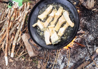 ön plana açık havada yangında, kızarmış balık siyah wok tava